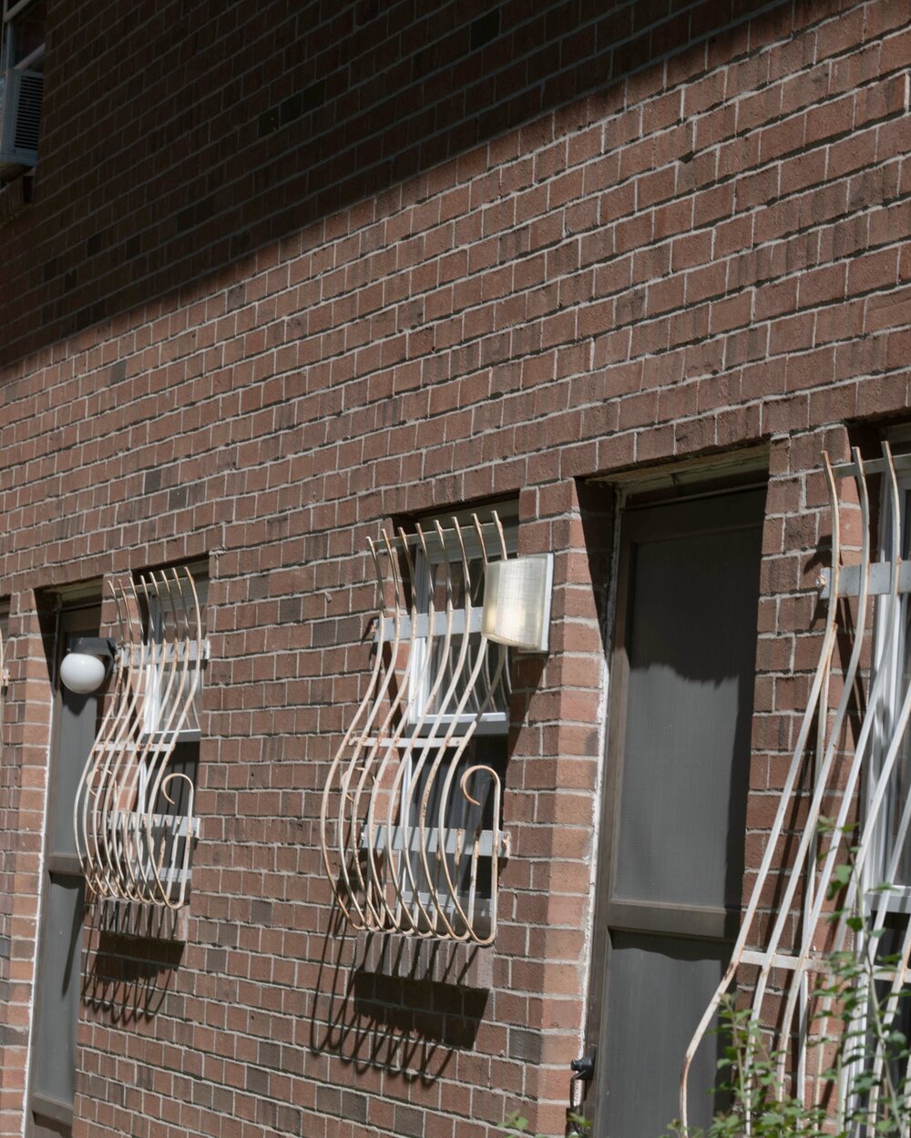 Brick apartment facade in Hartford, Connecticut, with wrought-iron window guards and an entry door